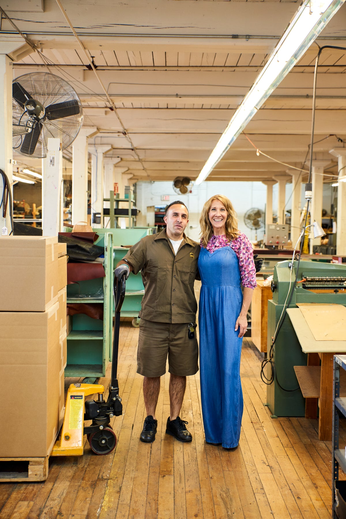 Accessories designer, Paula Parisotto, in her Connecticut manufacturing warehouse standing with the UPS driver who takes her first cork purse collection for shipment to Solvang, California. 